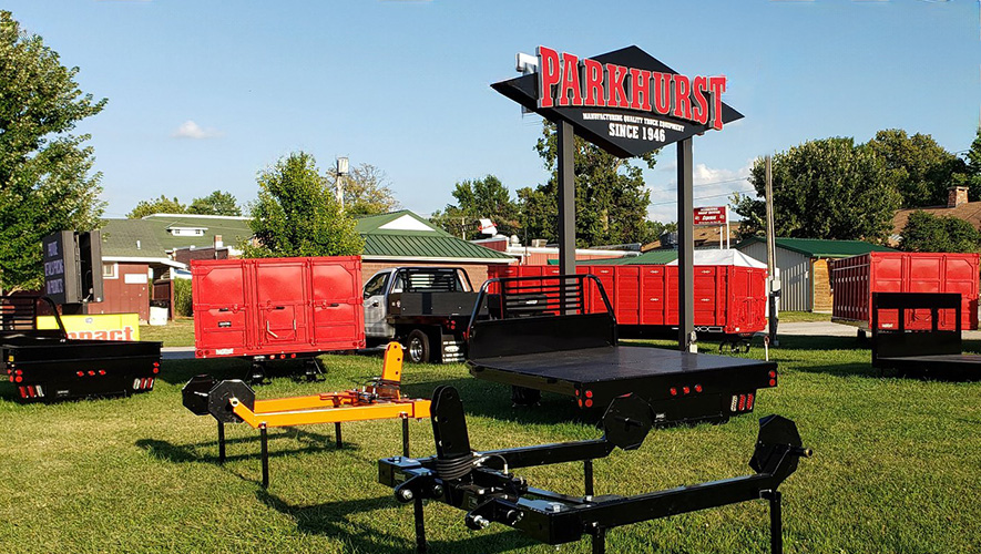 The Parkhurst sign outdoors surrounded by various types of truck bodies for display
