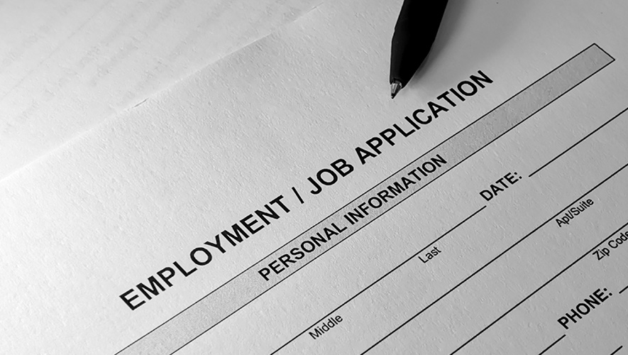 An employment application and pen