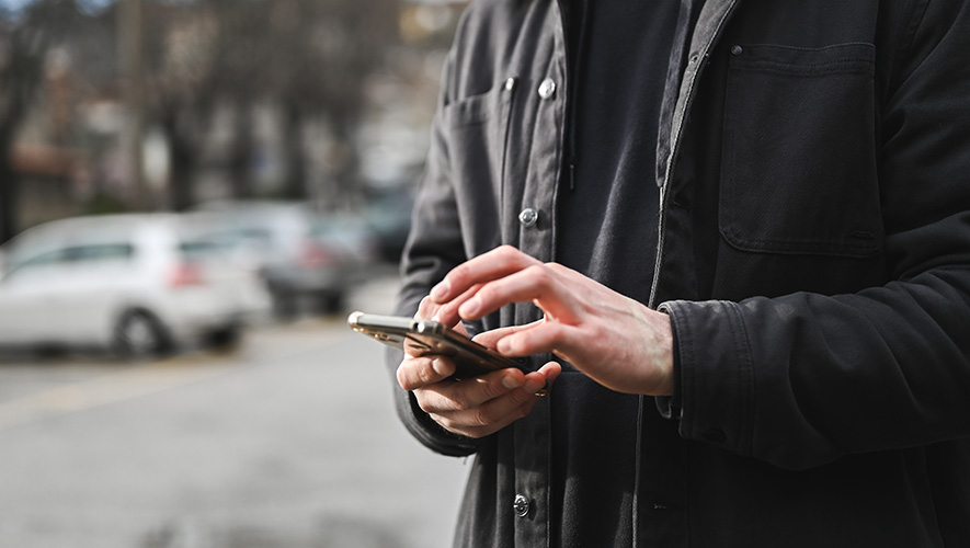 A man standing outside and getting ready to make a call