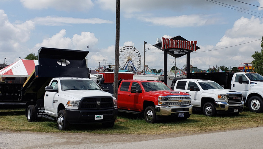 Four Parkhurst work trucks displayed at a fair