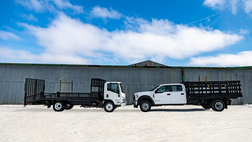 Two trucks with Parkhurst bodies facing each other outside a warehouse