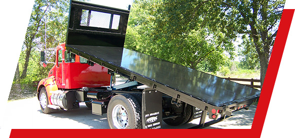 A truck with the truck bed tilted showing the harsh hoist