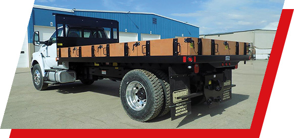 A heavy duty Parkhurst work truck body with racks parked outside a commercial building